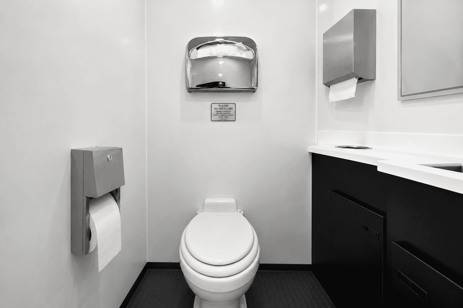 Stainless steel vanity and full-height mirror inside restroom trailer